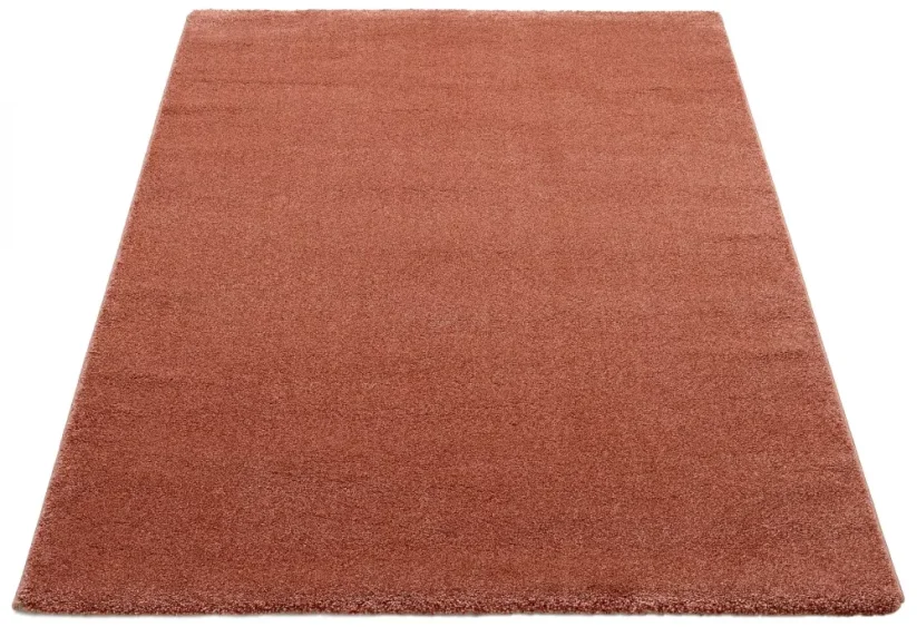 Štvorcový červeno ružový koberec je z jednej strany o niečo svetlejší ako z druhej. Stačí ho otočiť, jemne zmení farbu.