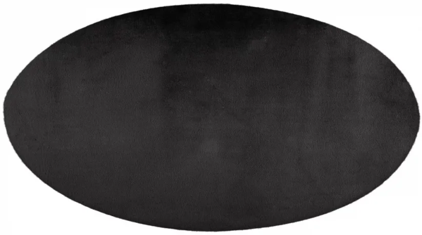 Tmavo šedý kruhový koberec z plyšového materiálu sa hodí ku kreslu či k posteli.