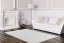 Veľký béžový koberec v obývačke s jemným a moderným orientálnym motívom.