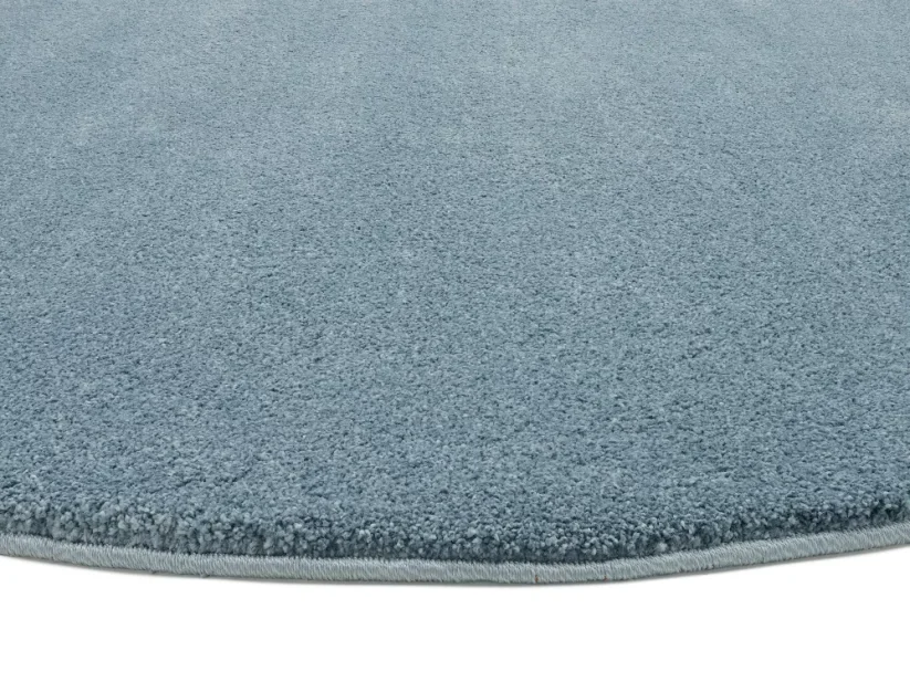 Modrý kruhový koberec je elegantne obšitý vo farbe koberca.