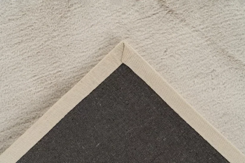 Obdĺžnikový ako aj kruhový koberec má lemovanú hranu krémovou stuhou.