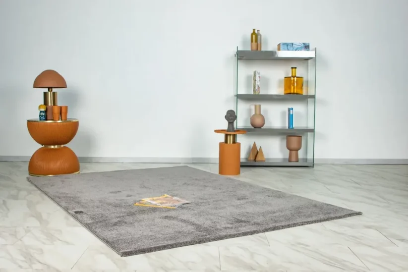 Sivý koberec je z jednej strany o niečo svetlejší a druhej tmavší, je to spôsobené jemným leskom koberca.